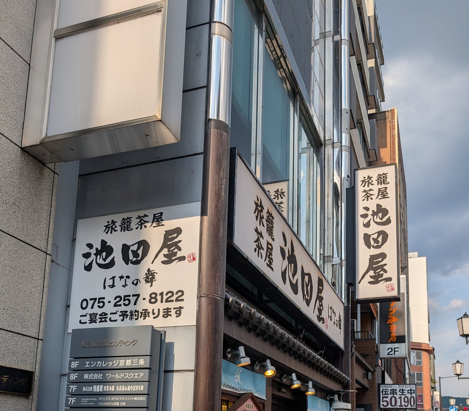 三条通に並ぶ「池田屋」の袖看板。跡地の建物は当時のものではないが、屋号は今も店の名として掲げられている(2026-08-22 撮影)